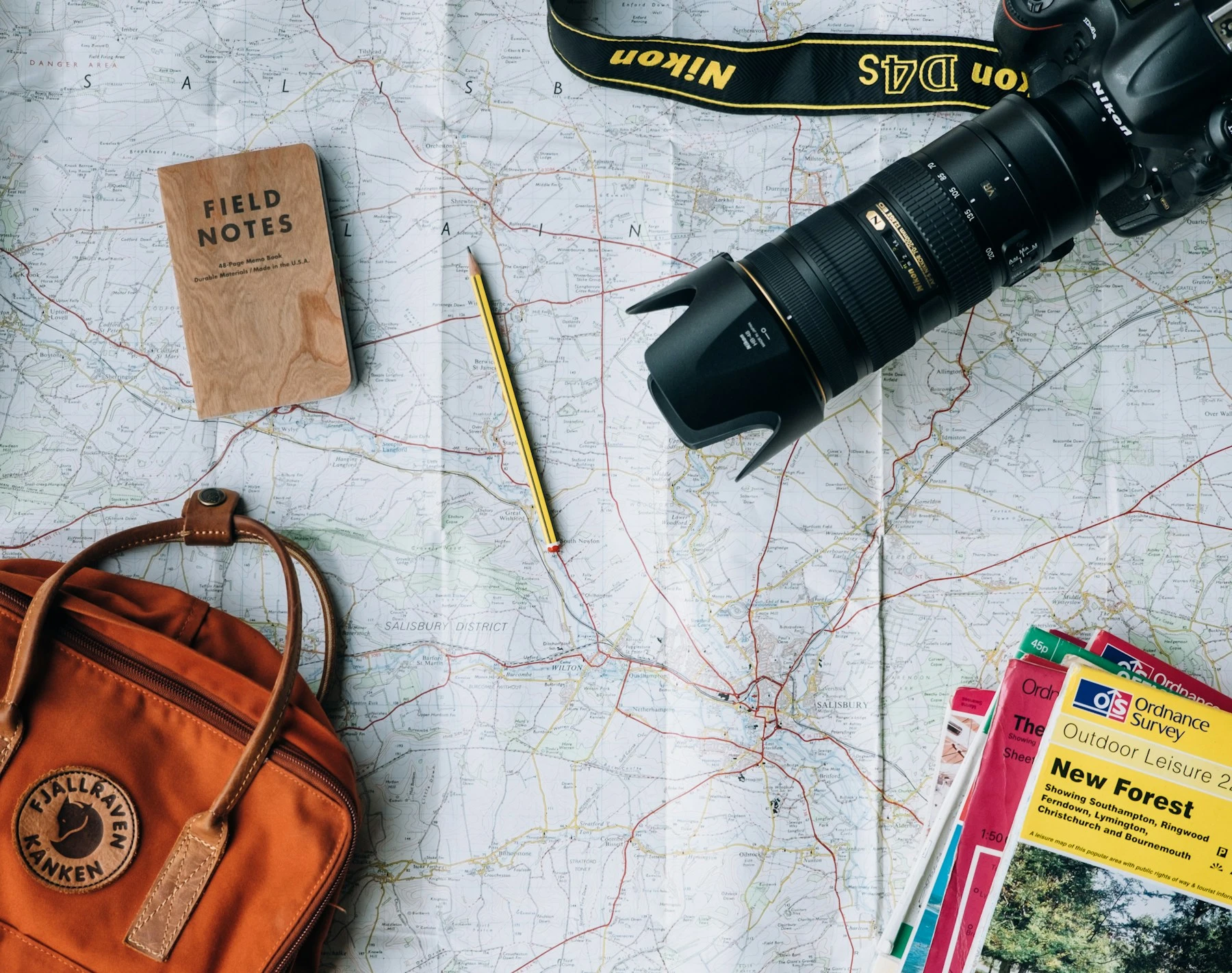 A travel notebook, map and camera ready for a journey